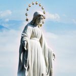 Estatua de Madre María extendiendo sus brazos en compasión